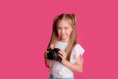 Portrait of a girl traveler, about traveling, holding a camera in her hands, on a pink background clipart