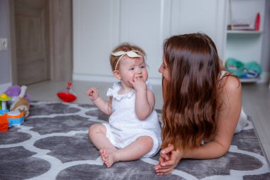 Anne ve kızı yerde oynuyorlar.