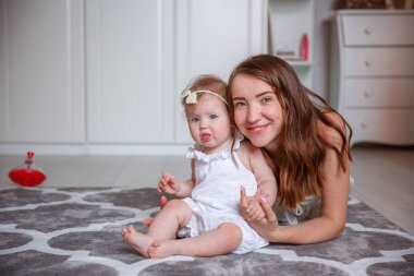 Anne ve kızı yerde oynuyorlar.