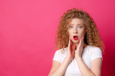 Pembe arka planda poz veren güzel kız. 