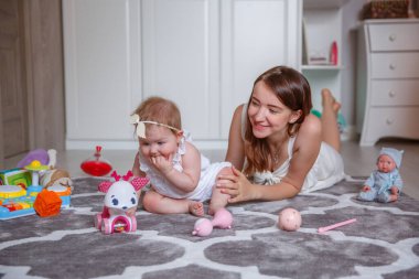 Anne ve kızı yerde oynuyorlar.