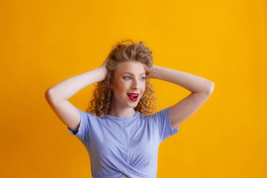 Turuncu arka planda poz veren güzel kızıl kadın portresi