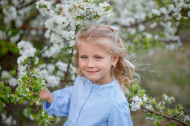 Çiçek açan bir ağacın yanında küçük bir kız