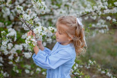 Çiçek açan bir ağacın yanında küçük bir kız