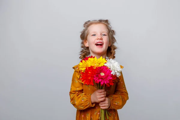 Portré Egy Gyönyörű Kislányról Egy Csokor Virággal Szürke Háttéren — Stock Fotó
