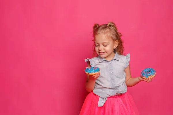 Fröhliches Kleines Mädchen Mit Donuts Auf Rosa Hintergrund — Stockfoto