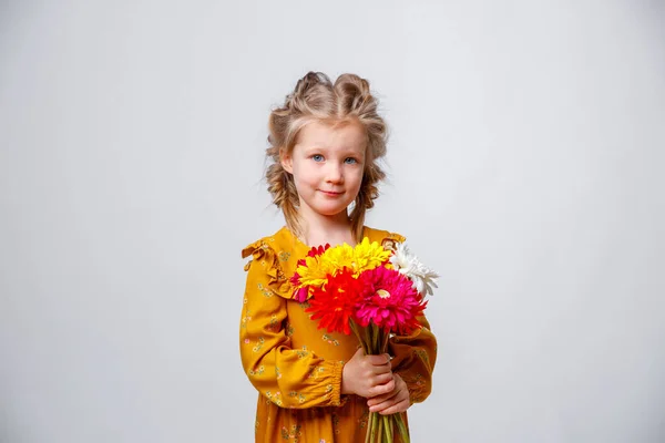 Gri Arka Planda Bir Buket Çiçekle Sarı Elbiseli Şirin Küçük — Stok fotoğraf