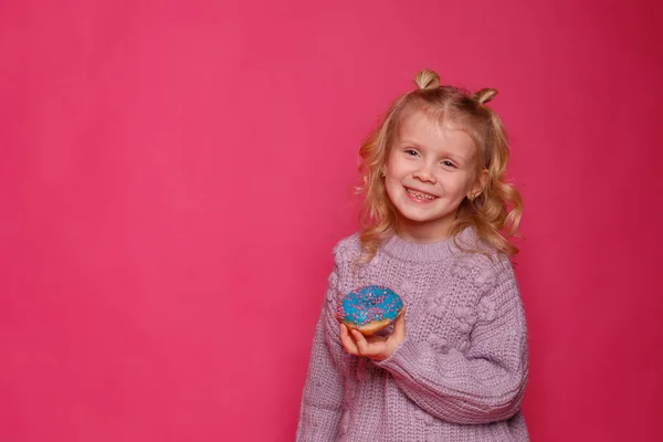 Fröhliches Kleines Mädchen Mit Einem Donut Auf Rosa Hintergrund — Stockfoto