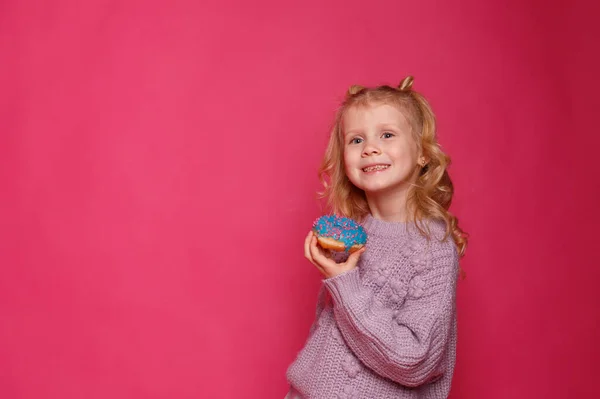 Fröhliches Kleines Mädchen Mit Einem Donut Auf Rosa Hintergrund — Stockfoto