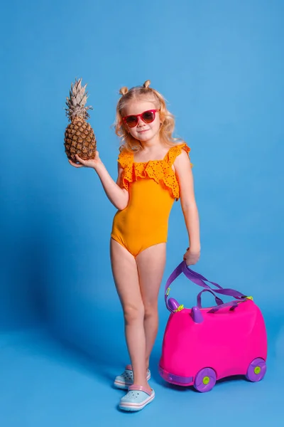 Mavi Arka Planda Mayo Giymiş Bavulu Ananaslı Küçük Bir Kız — Stok fotoğraf