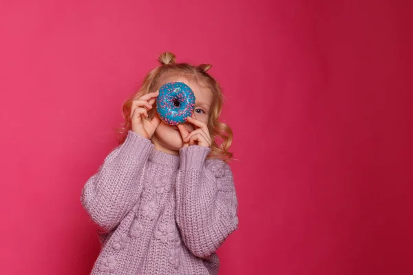 Fröhliches Kleines Mädchen Mit Einem Donut Auf Rosa Hintergrund — Stockfoto