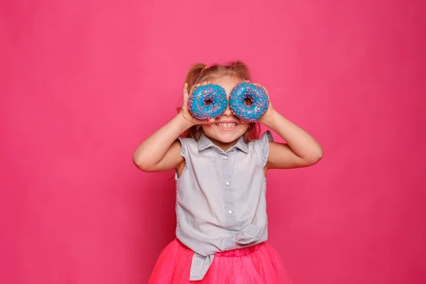 Niña Alegre Con Donuts Sobre Fondo Rosa — Foto de Stock