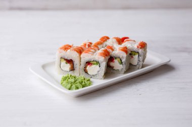 Suşi beyaz tabakta yuvarlanıyor.