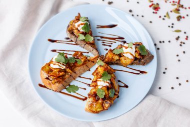 Lezzetli ızgara somon, sebzeli ve soslu beyaz tabak.