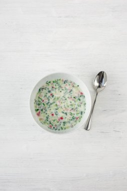 yeşil bezelye çorbası, kaşık ve ahşap zemin üzerinde taze sebzeler.