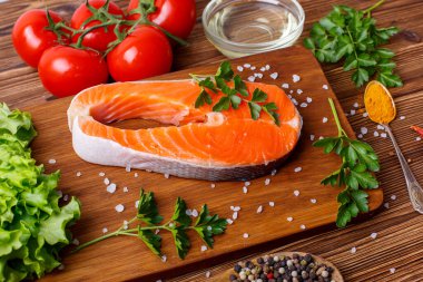 Ahşap arka planda sebzeli ve baharatlı somon bifteği. Yemek pişirme kavramı. Bakkal geçmişi.