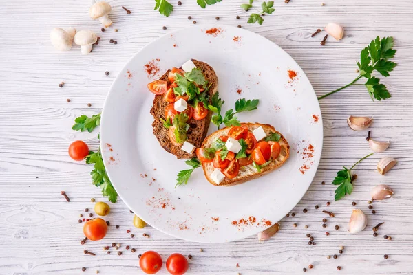 Çeri domatesli, şifalı otlu ve peynirli kızarmış ekmek.