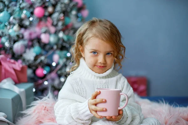 Una Bambina Vicino All Albero Natale Che Tiene Una Tazza — Foto Stock