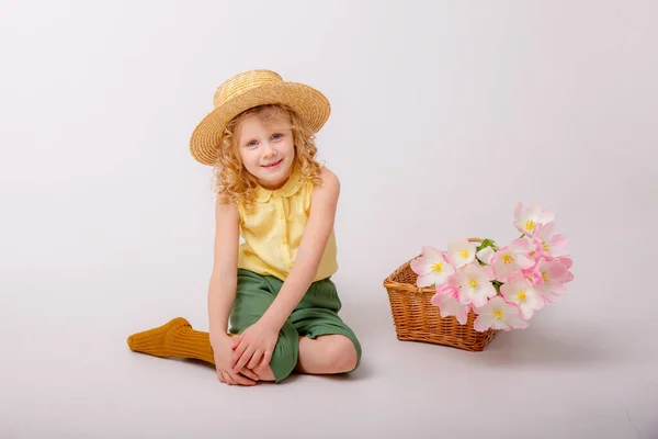 Beyaz Arka Planda Bir Sepet Pembe Çiçekli Küçük Sarışın Kız — Stok fotoğraf