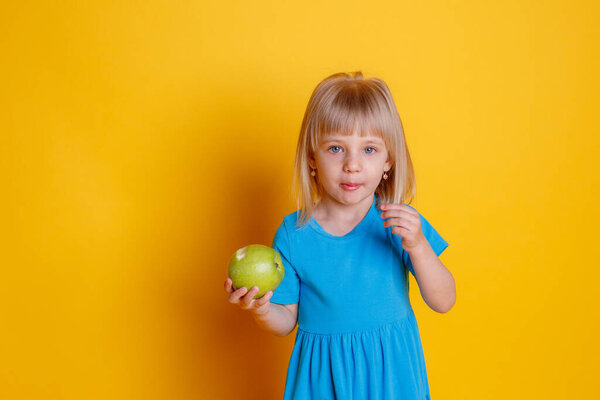 baby girl holding a green Apple 