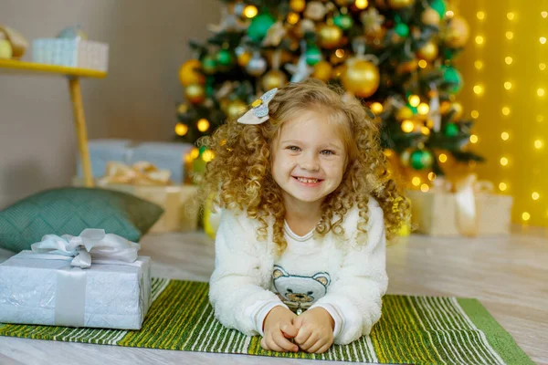 Una Bambina Vicino All Albero Natale Sdraiata Sul Pavimento — Foto Stock
