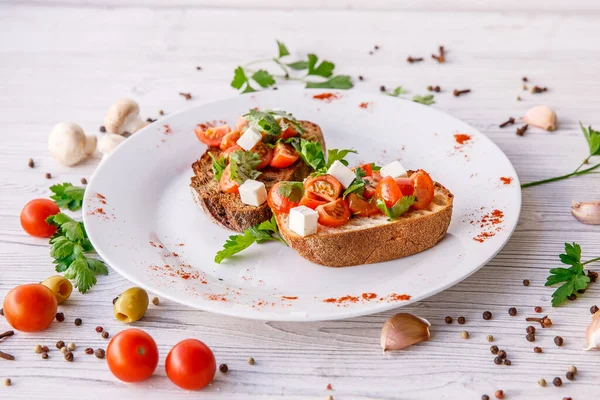 Çeri domatesli, şifalı otlu ve peynirli kızarmış ekmek.