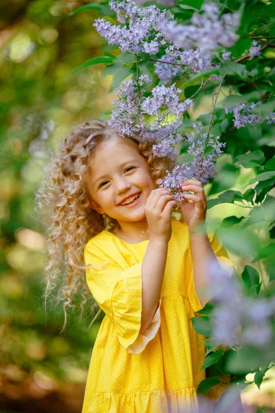 Piękna Mała Dziewczynka Pozowanie Liliowe Kwiaty — Zdjęcie stockowe