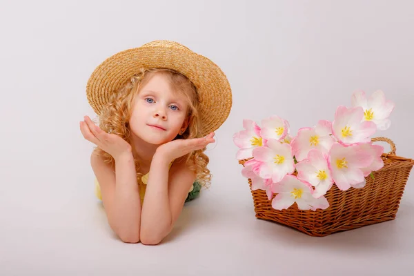 Beyaz Arka Planda Bir Sepet Pembe Çiçekli Küçük Sarışın Kız — Stok fotoğraf