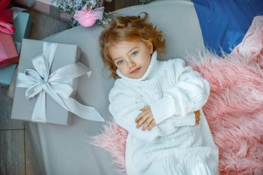 Noel ağacının yanında küçük bir kız yatağında yatıyor. 