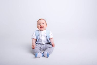 Stüdyoda Gray 'e karşı poz veren sevimli erkek bebek.