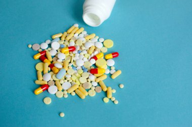 Şişenin üstünden renkli haplar ve kapsüller dökülüyor. Tıbbi haplar, ağrı kesiciler, antibiyotikler, vitaminler ve cam kavanoz. Eczane, tıbbi klinik, eczane afişi tasarım şablonu