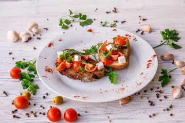 Çeri domatesli, şifalı otlu ve peynirli kızarmış ekmek.