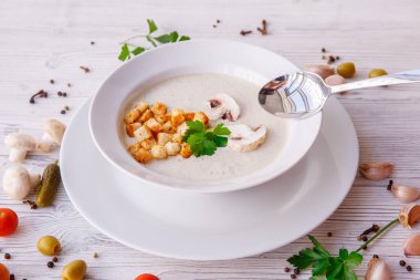 Krema çorbasını mantar ve krakerle kapat.