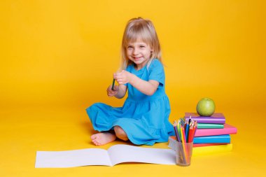 Okul öncesi eğitim kavramı, kitap yığını ve elma ile turuncu arka plan