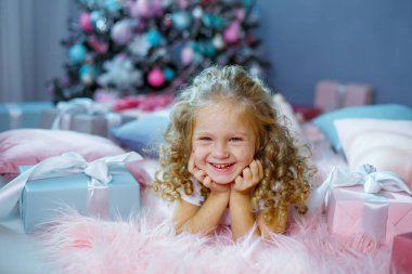 Noel ağacının yanında küçük bir kız yatağında yatıyor. 