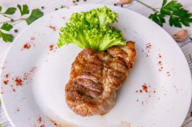 Kızarmış domuz bifteğini marulla kapat.