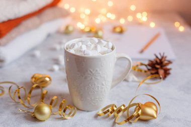 Yeni yıl arkaplanında parıldayan bir çelenkle kahve ve marshmallow bardağı.