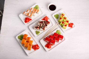 Suşi tahtadaki beyaz tabaklar üzerine kurulmuş.