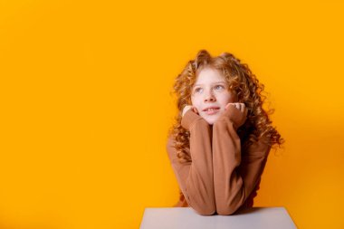 Portakala karşı poz veren hayalperest genç kız. 