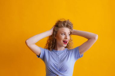 Stüdyoda turuncu arka planda poz veren güzel kızıl kadın.