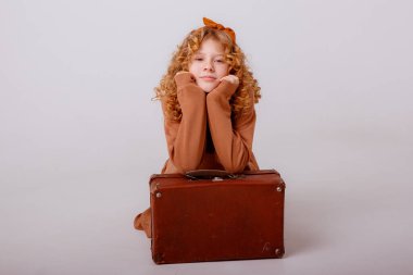 Stüdyoda bavulla poz veren genç kız..