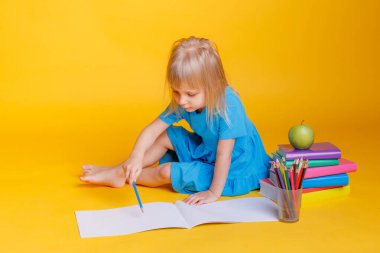 Okul öncesi eğitim kavramı, kitap yığını ve elma ile turuncu arka plan