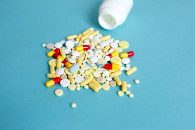 Şişenin üstünden renkli haplar ve kapsüller dökülüyor. Tıbbi haplar, ağrı kesiciler, antibiyotikler, vitaminler ve cam kavanoz. Eczane, tıbbi klinik, eczane afişi tasarım şablonu
