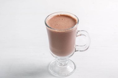 Tahta arka planda bir bardak lezzetli çikolatalı smoothie.