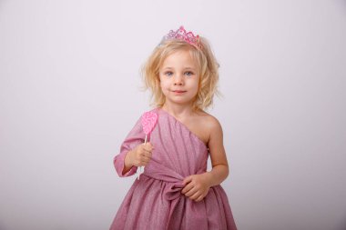 Güzel sarışın kız kalp şeklinde lolipopla poz veriyor. 