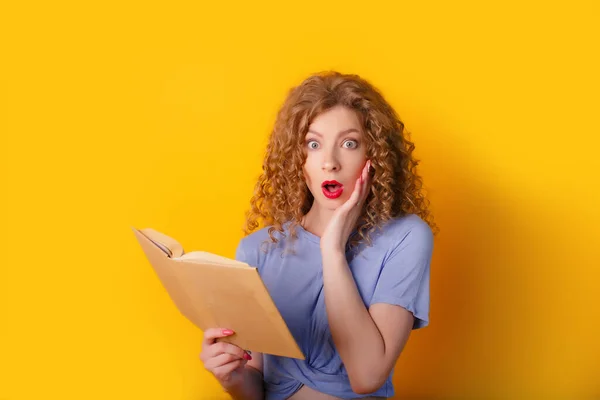 beautiful woman posing with book against orange background