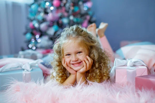 Una Bambina Vicino All Albero Natale Sdraiata Sul Letto — Foto Stock