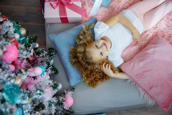 Una Bambina Vicino All Albero Natale Sdraiata Sul Letto — Foto Stock
