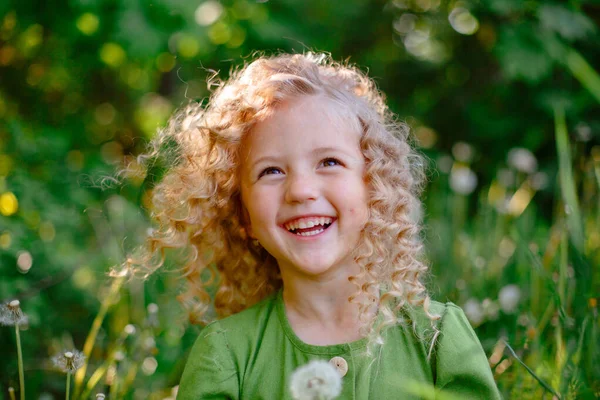 Pequena Loira Encaracolado Menina Vestido Verde Soprando Segurar Dente Leão — Fotografia de Stock