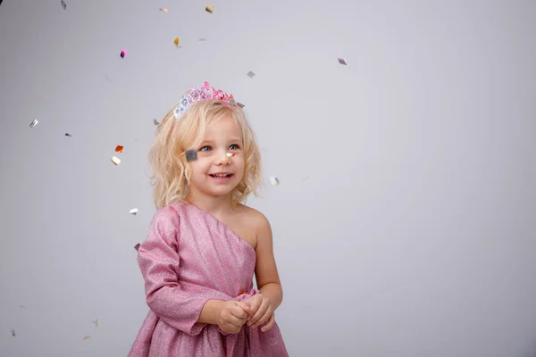 漂亮的小女孩穿着粉红的衣服 头戴皇冠 在演播室里摆姿势 — 图库照片